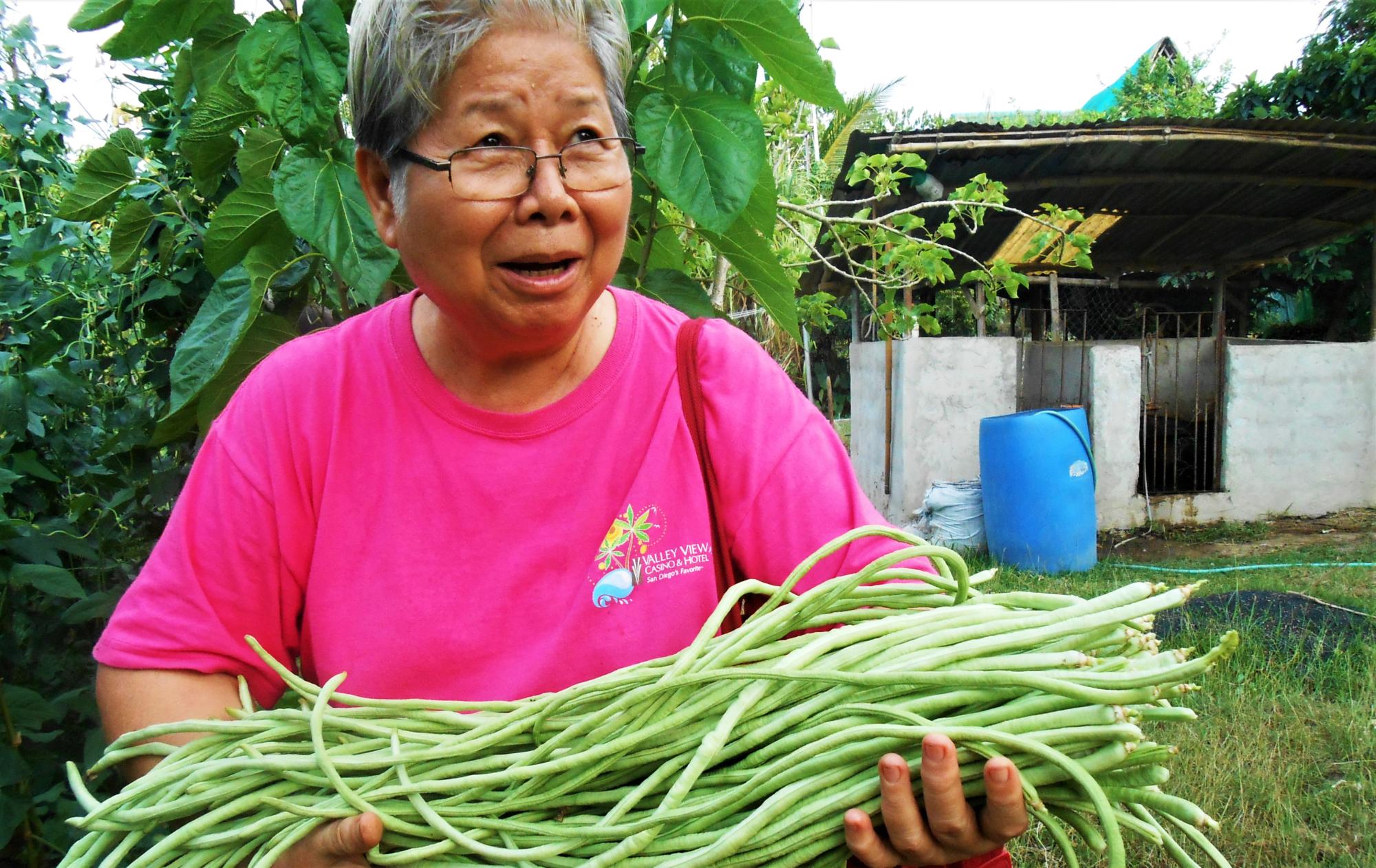 Sister Anne carries a harvest of beans
