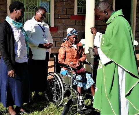 The priest blesses Cynthia's new wheelchair