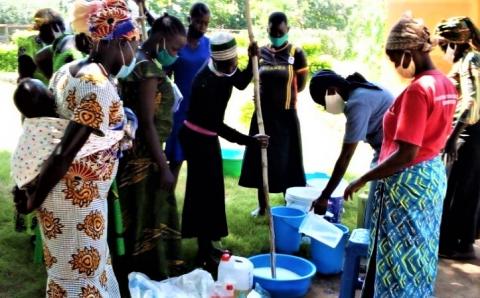 Women refugees prepare liquid soap to hand wash during the pandemic