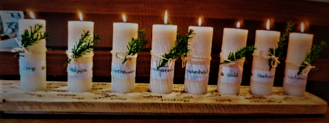 Candles on the length of wood engraved with names of Unit members