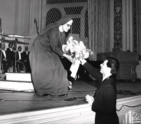 Sister Miriam Therese Winter receives a floral bouquet after the performance 