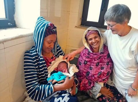 Sister Rita Schiffer greets a newborn