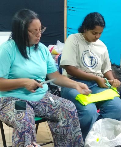 Children and volunteers at Latidos cut cloth together