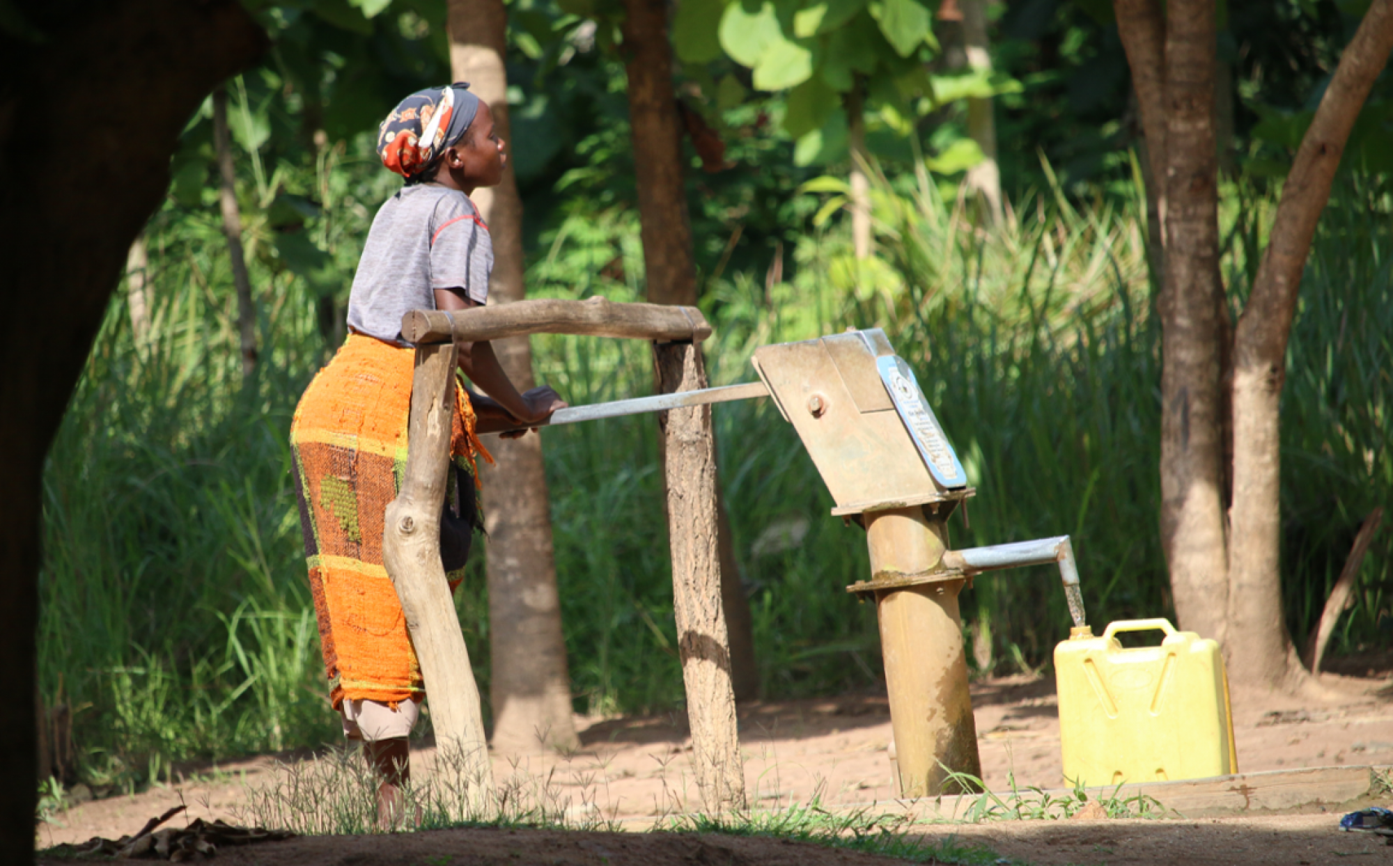 A refugee women fetches water at a local well in Northern Uganda
