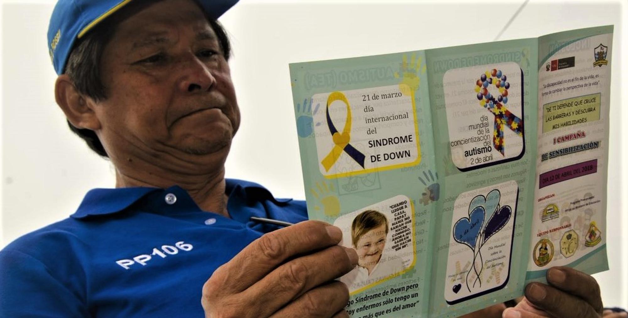 Peruvian father reads a brochure about Down syndrome