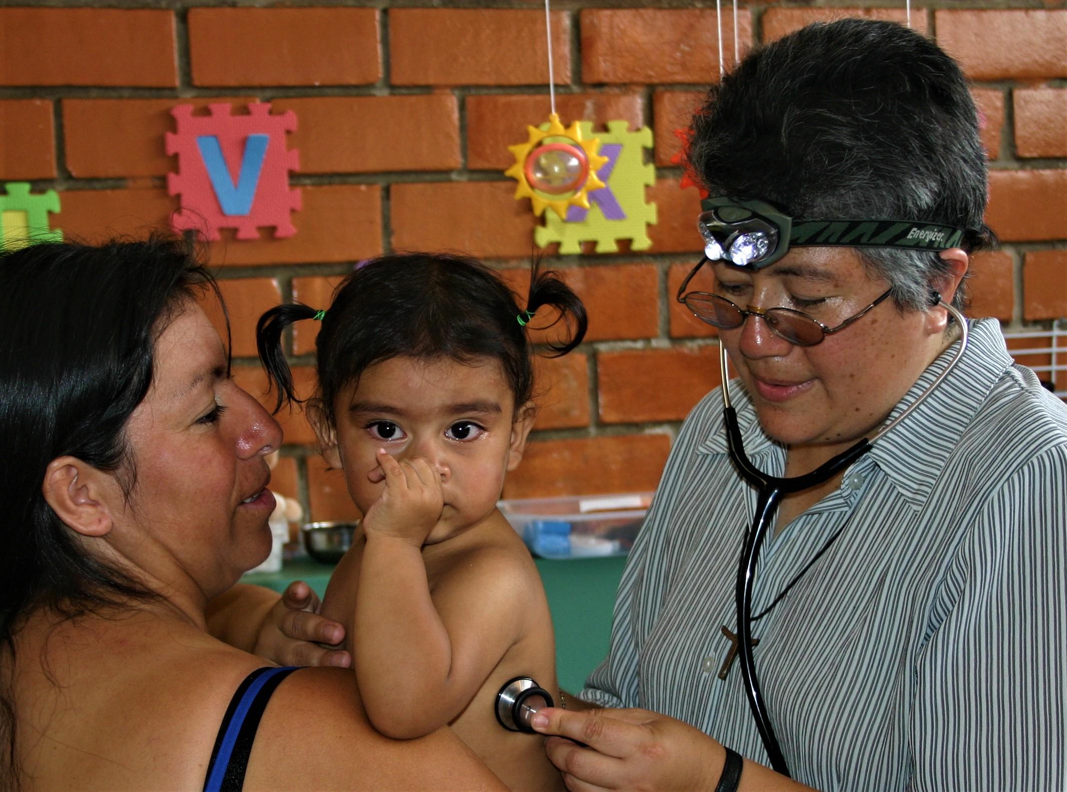 Sister Mafe examines a child at a clinic in Peru
